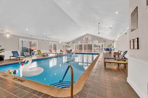 Southfield apartment for rent - A large indoor swimming pool with a slide and lounge chairs.