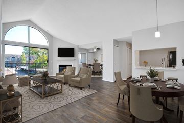 Southfield apartment for rent - A modern living room with a fireplace and a dining table set up.