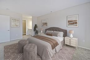 Southfield apartment for rent - A bedroom with a large bed and a nightstand with a lamp.