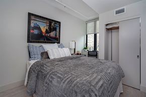 Lansing apartment for rent - A bedroom with a large bed and a painting above it.