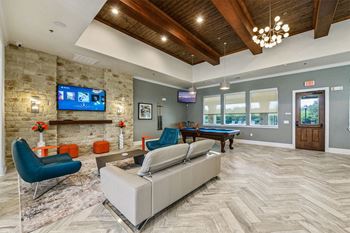 Clubhouse with lounge seating, tvs, and pool table