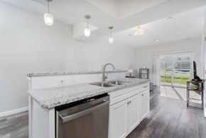 Grove City apartment for rent - A kitchen with white cabinets and a granite countertop.