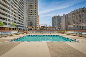 Detroit apartment for rent - A large swimming pool on a rooftop with buildings in the background.