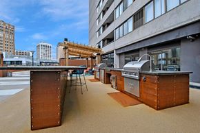 Detroit apartment for rent - an outdoor kitchen with stainless steel appliances and wooden cabinets on a building