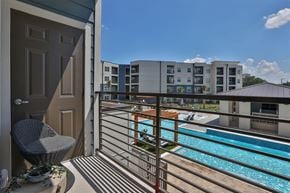 New Braunfels apartment for rent - A balcony with a chair and a pool in the background.