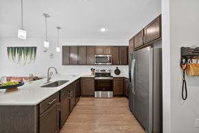 San Antonio apartment for rent - A modern kitchen with a refrigerator, sink, and oven.