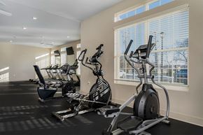 Columbus apartment for rent - A gym with a row of exercise bikes and elliptical machines.