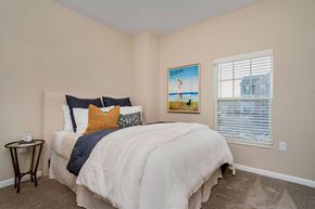 Columbus apartment for rent - A bedroom with a bed, pillows, a nightstand, and a painting on the wall.