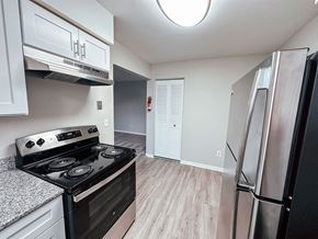 Kalamazoo apartment for rent - A kitchen with a black stove top oven and a refrigerator.