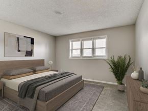 West Des Moines apartment for rent - A bedroom with a large bed and a potted plant.