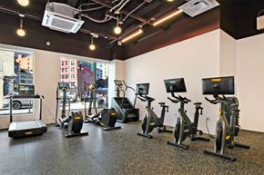Detroit apartment for rent - a gym with various exercise equipment on the floor and a window