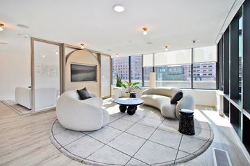 Detroit apartment for rent - a living room with two couches and a table in front of a large window