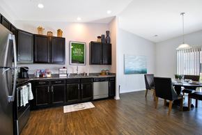 East Lansing apartment for rent - A kitchen with black cabinets and a wooden floor.