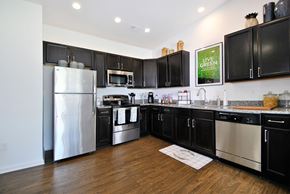East Lansing apartment for rent - A kitchen with black cabinets and stainless steel appliances.