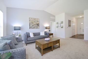 East Lansing apartment for rent - A living room with a grey couch and a wooden coffee table.