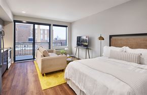 Saint Paul apartment for rent - A bedroom with a large bed and a balcony overlooking the city.