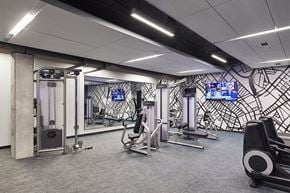 Saint Paul apartment for rent - A gym with a variety of equipment including a treadmill, weights, and a television.