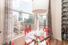 Chicago apartment for rent - a dining room with a large window and a table with red chairs