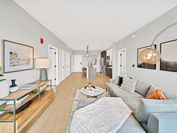 Elmhurst apartment for rent - A well-lit, modern living room with a grey sofa and a wooden coffee table.
