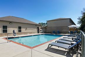 Conway apartment for rent - A pool with sun loungers and a building in the background.