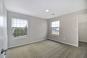 Howell apartment for rent - A spacious room with two windows and carpeted floor.