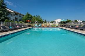Howell apartment for rent - A swimming pool with a blue tinted water and sun loungers.