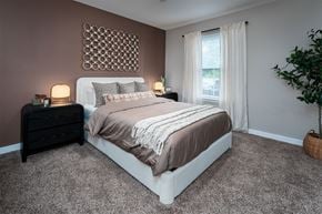 Highland Heights apartment for rent - A bedroom with a large bed and a window with curtains.