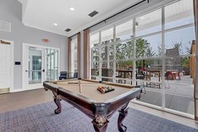 Perrysburg apartment for rent - A pool table in a room with a view of the backyard.