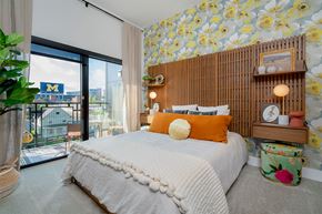 Ann Arbor apartment for rent - A bedroom with a large bed and a wallpapered wall.