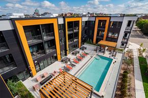 Ann Arbor apartment for rent - A modern apartment complex with a pool and outdoor seating area.