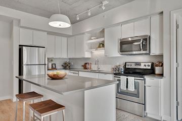 Minneapolis apartment for rent - A modern kitchen with white cabinets and stainless steel appliances.