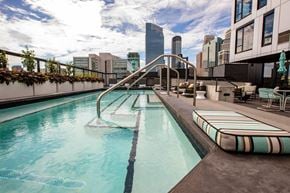 Minneapolis apartment for rent - A pool with a slide and a city skyline in the background.