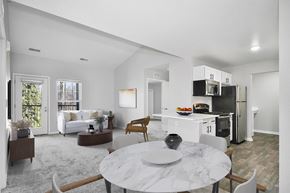 East Lansing apartment for rent - A modern kitchen with a dining table and chairs in the foreground.