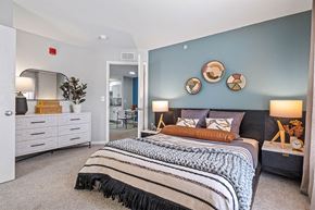 East Lansing apartment for rent - a bedroom with a bed and a blue wall