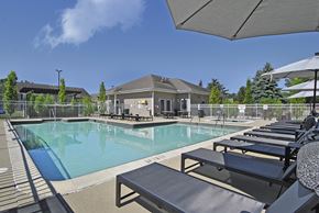 East Lansing apartment for rent - A pool with sun loungers and a building in the background.