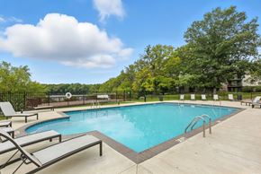 Hobart apartment for rent - A large outdoor swimming pool surrounded by lounge chairs.