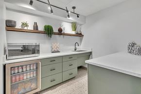 Hobart apartment for rent - a kitchen with green cabinets and a counter top and a microwave