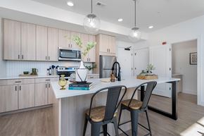 Pittsburgh apartment for rent - an open kitchen with a large island with three chairs