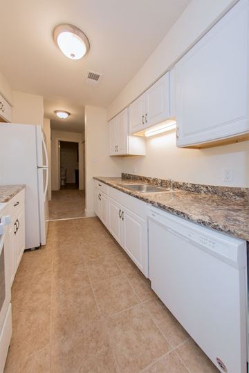 Hobart apartment for rent - a kitchen with white cabinets and a white refrigerator