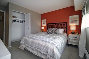 Lansing apartment for rent - A bedroom with a large bed and a white dresser.