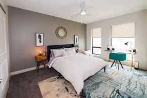 Cleveland apartment for rent - A bedroom with a large bed, a desk with a chair, and a rug on the floor.