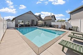 Blaine apartment for rent - A pool with a bench and a table with chairs is surrounded by a fence.