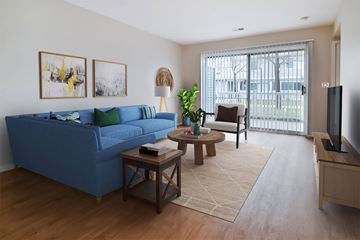 Holland apartment for rent - A blue couch sits in a living room with a wooden coffee table in front of it.