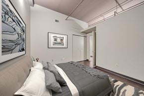 Detroit apartment for rent - A bedroom with a bed and a picture on the wall.