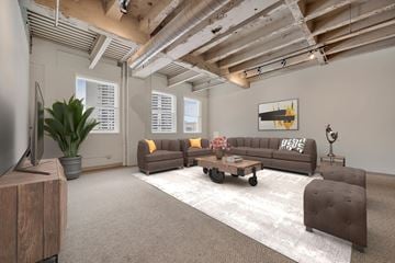 Detroit apartment for rent - A living room with a brown couch and a wooden cabinet.
