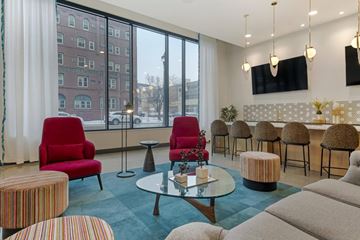 Minneapolis apartment for rent - A living room with a red chair and a glass table.
