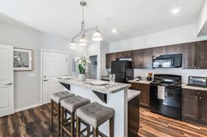 Columbus apartment for rent - A kitchen with a white island and black appliances.