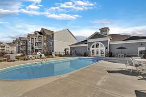 Columbus apartment for rent - A swimming pool in front of a building with a white exterior.