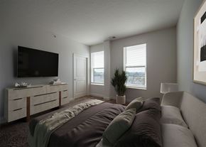 Columbus apartment for rent - A modern bedroom with a large bed and a flat screen TV.