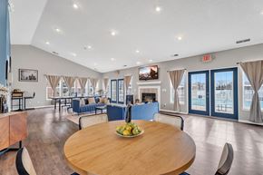 Southgate apartment for rent - A large room with a wooden table and chairs in the foreground and a pool in the background.